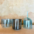 Load image into Gallery viewer, Three metallic crystal sound bowls of different sizes on a textured surface
