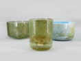Load image into Gallery viewer, Enchanted Forest 3 bowl harmonised set of Alchemy Crystal Tones Quartz Singing Bowls. Three bowls with green and blue hues on a light grey background.
