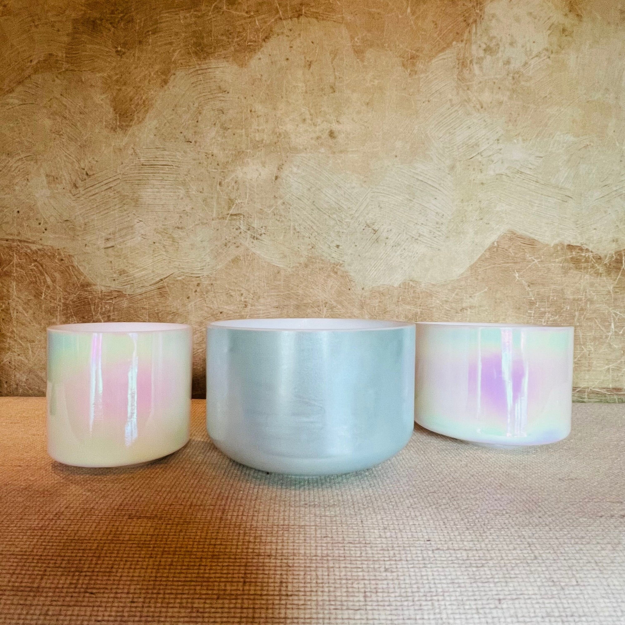 Three Crystal Sound Bowl with pastel glaze on a textured surface
