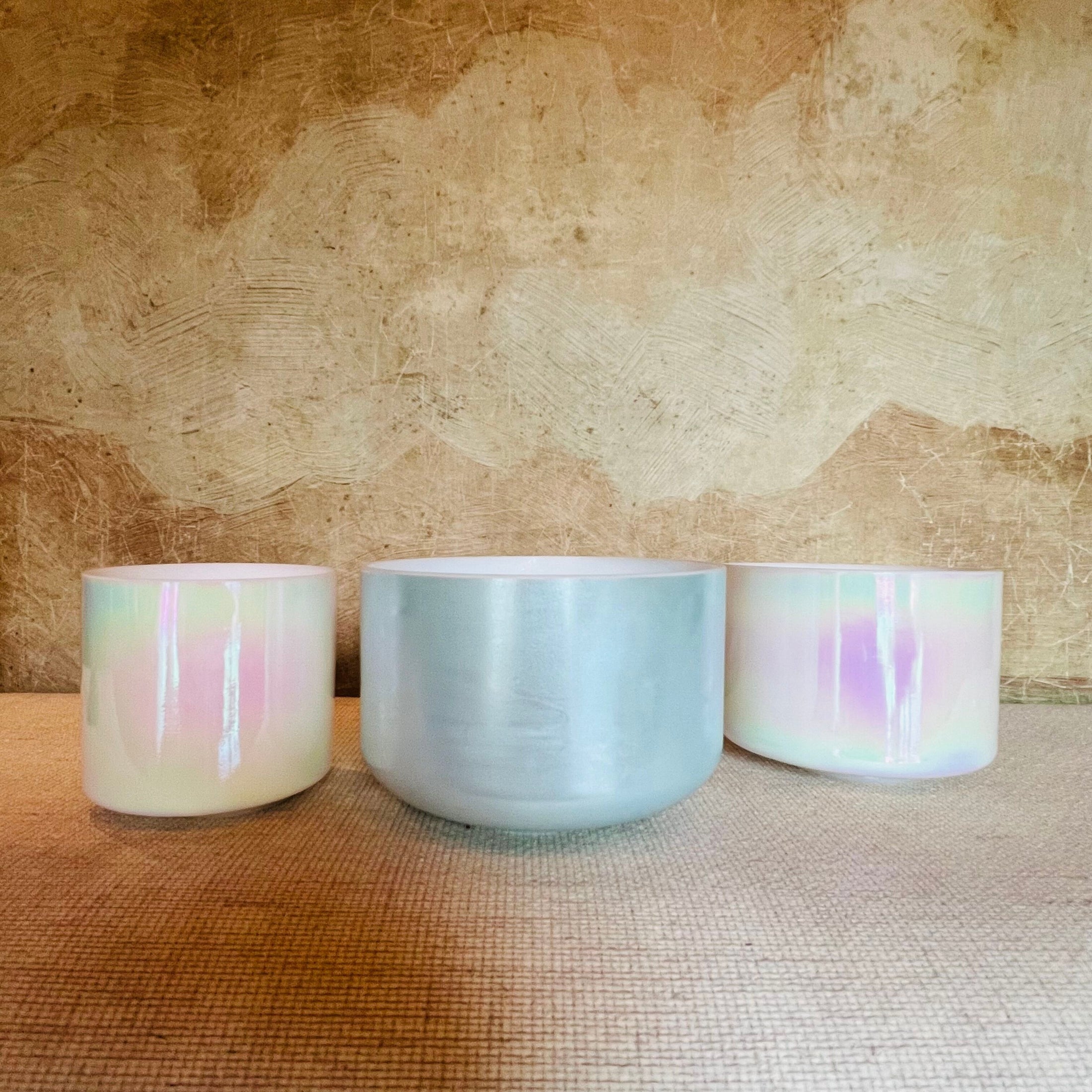 Three Crystal Sound Bowl with pastel glaze on a textured surface