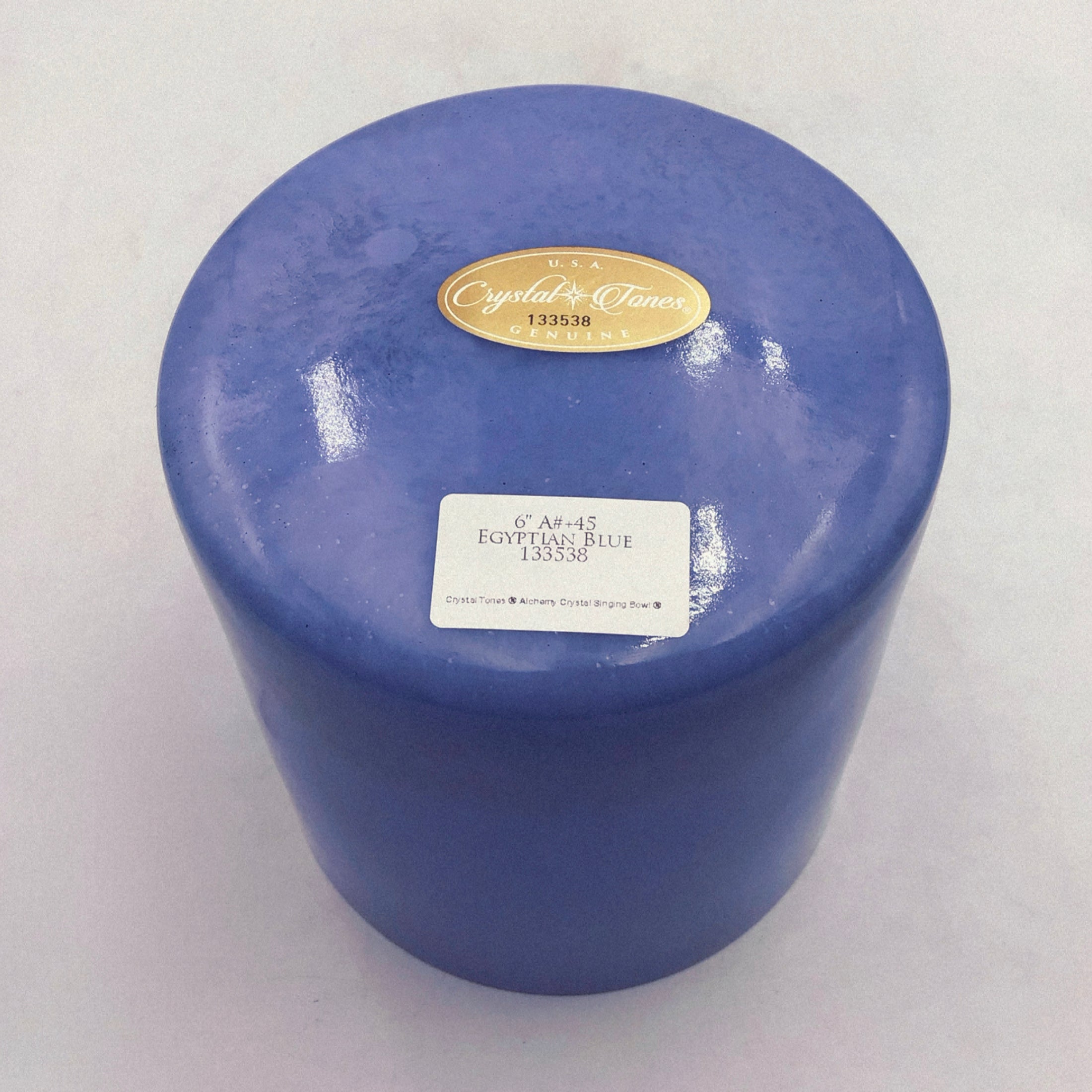 Blue crystal sound bowl with a label on a white background