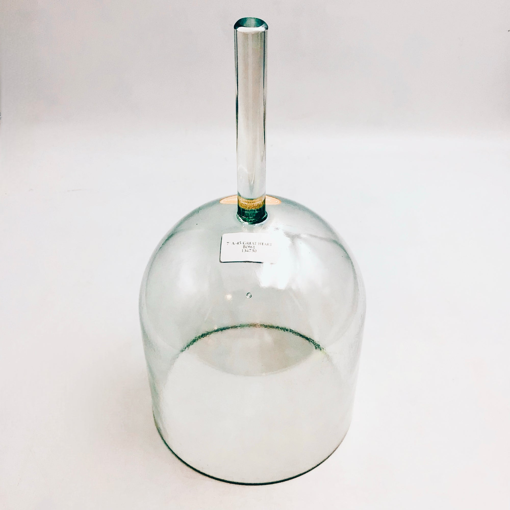 Clear glass Practitioner sound bowl with a handle on a white background