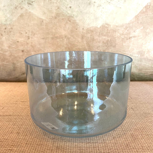 Clear crystal sound bowl on a textured surface