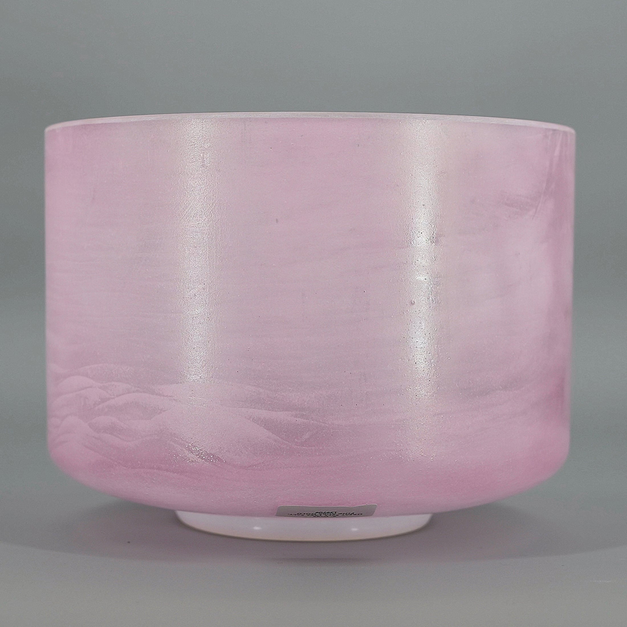 Pink crystal sound bowl on a gray background