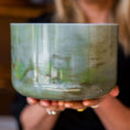 Load image into Gallery viewer, Person holding a green crystal sound bowl with 'Crystal Tones' branding.
