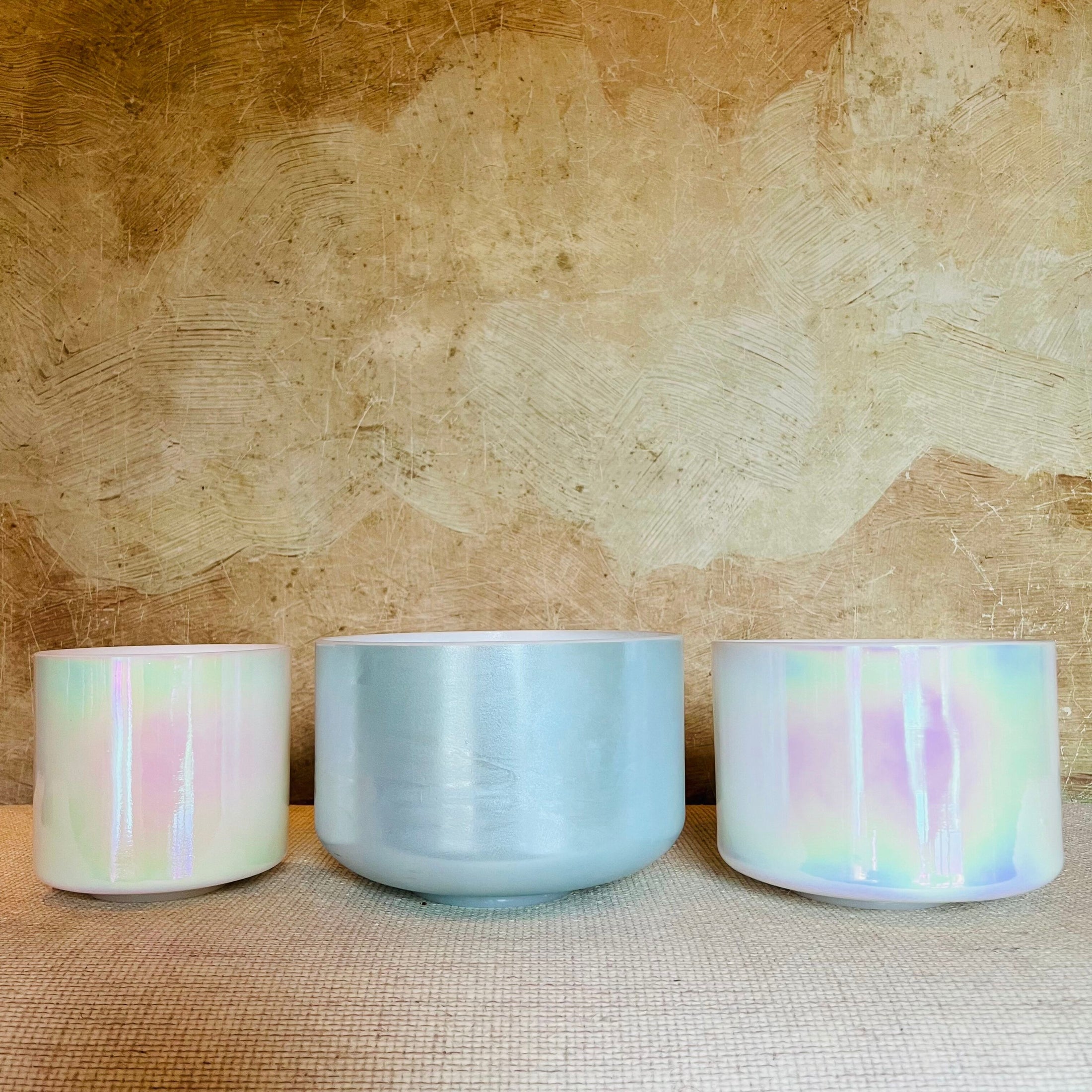 Three Crystal Sound Bowl with pastel color patterns on a textured surface.