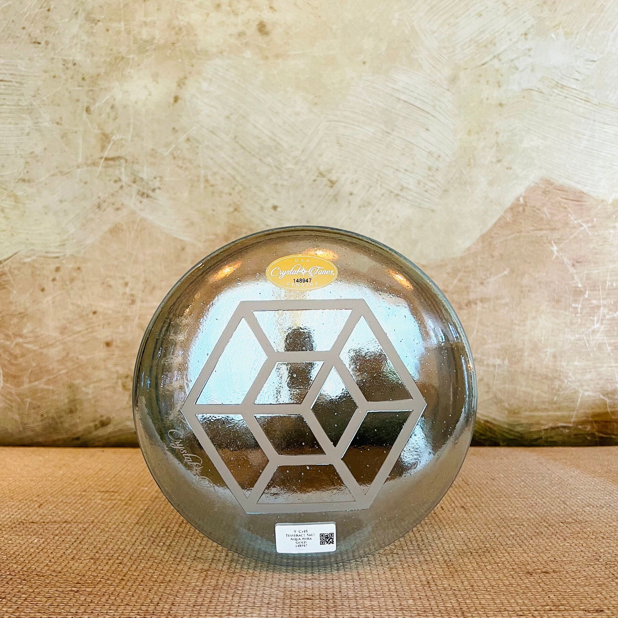 Clear crystal sound bowl with geometric design on a textured surface