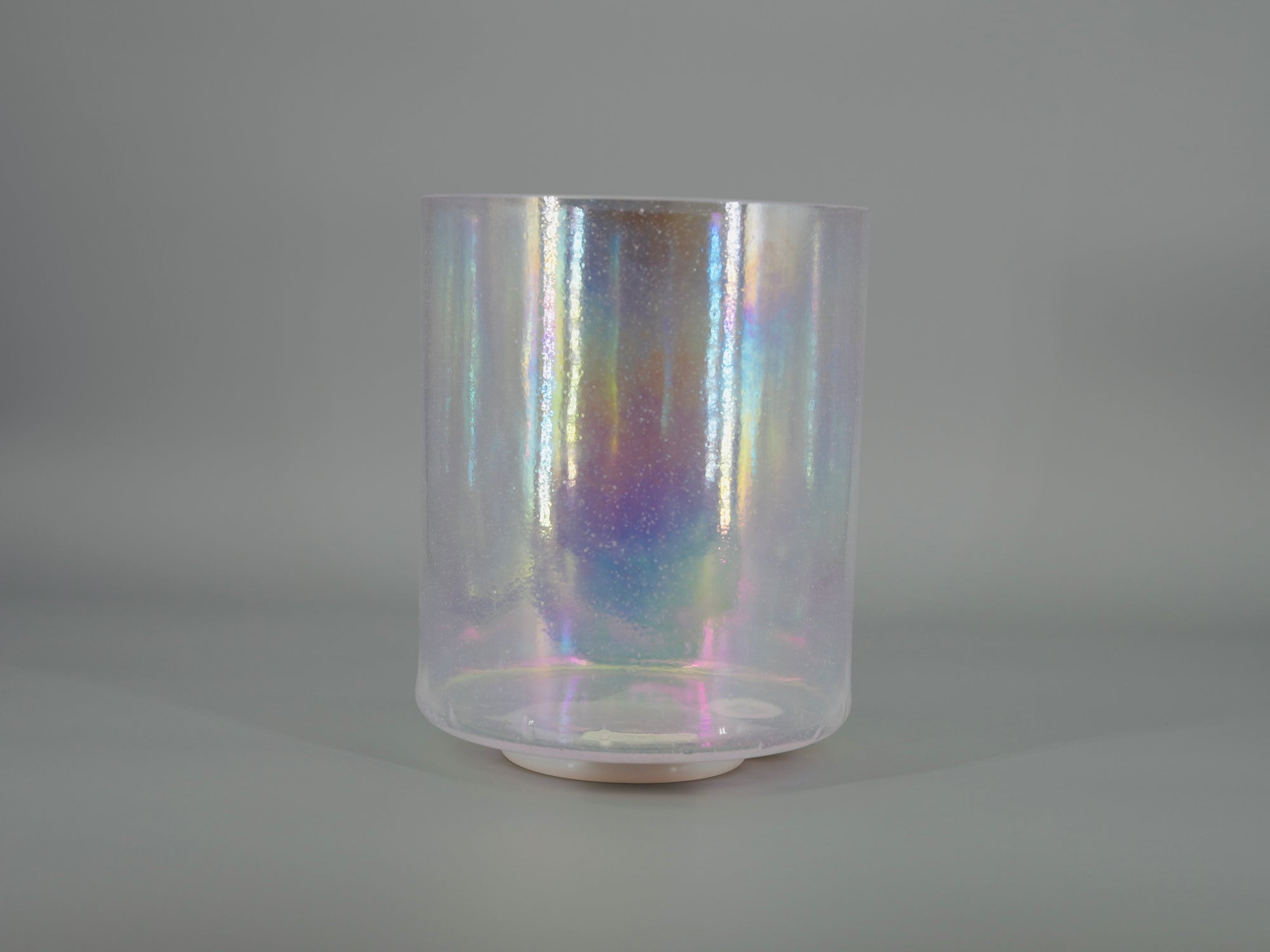 Iridescent crystal sound bowl on a gray background