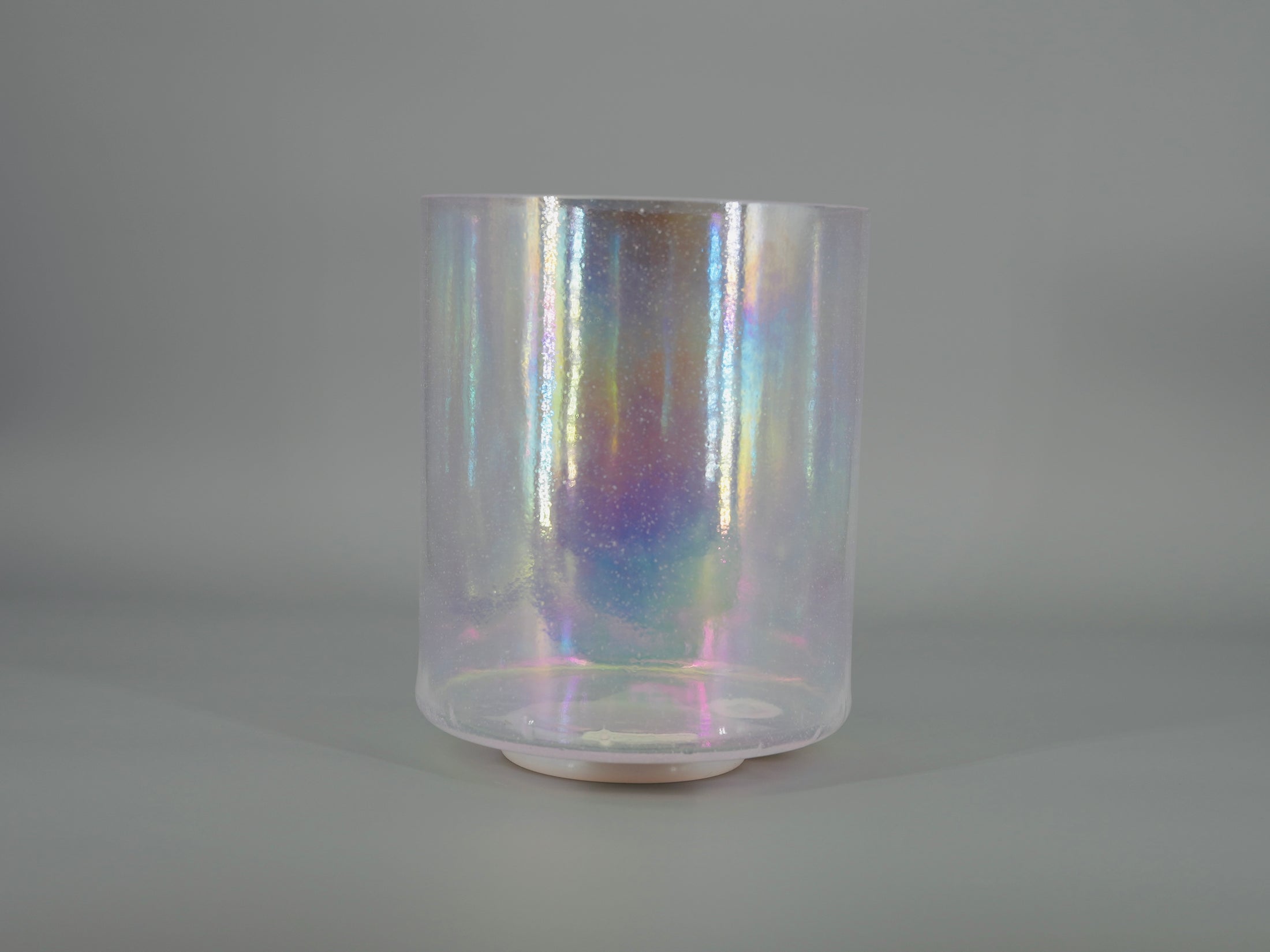 Iridescent crystal sound bowl on a gray background