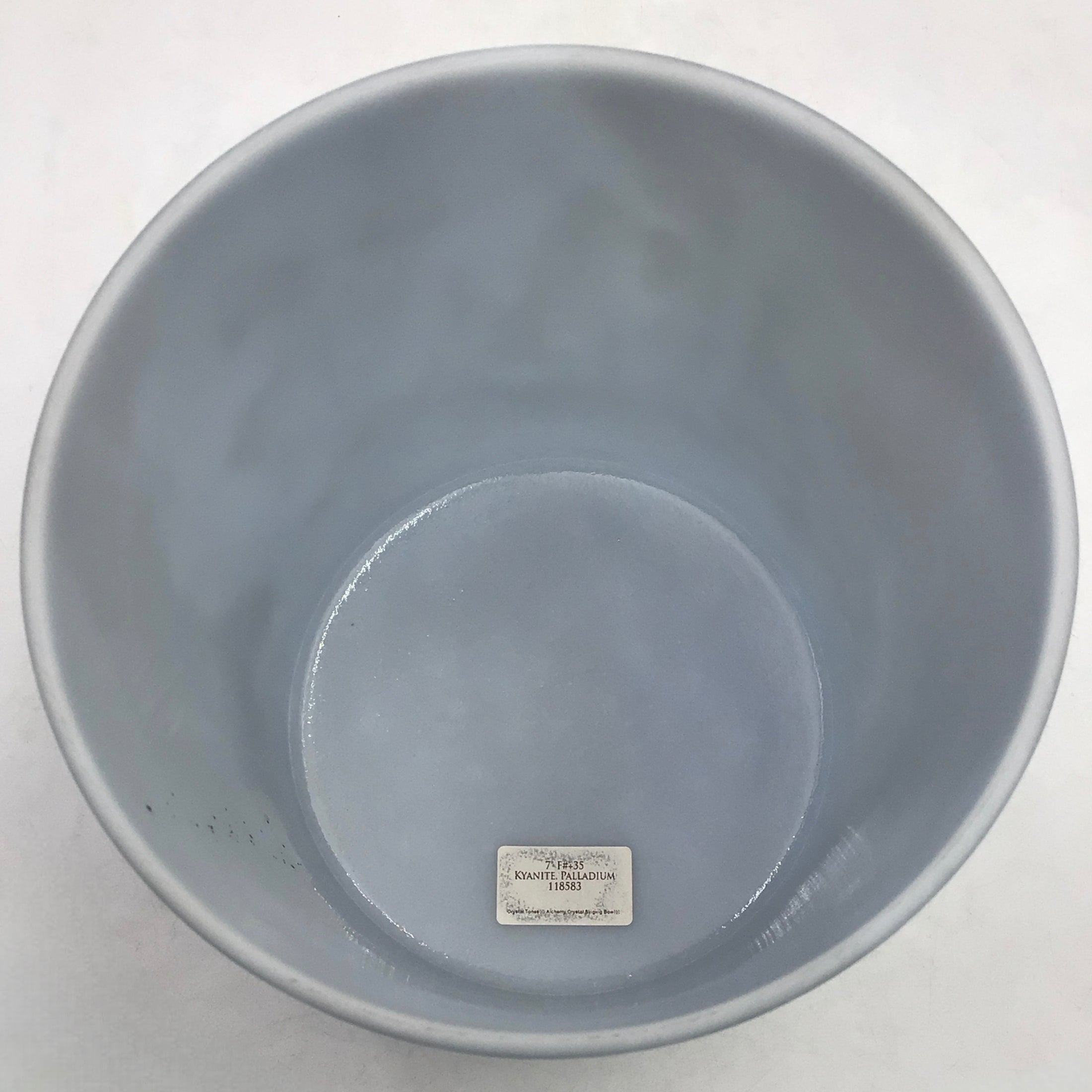 Gray crystal sound bowl with a visible brand label on a white background