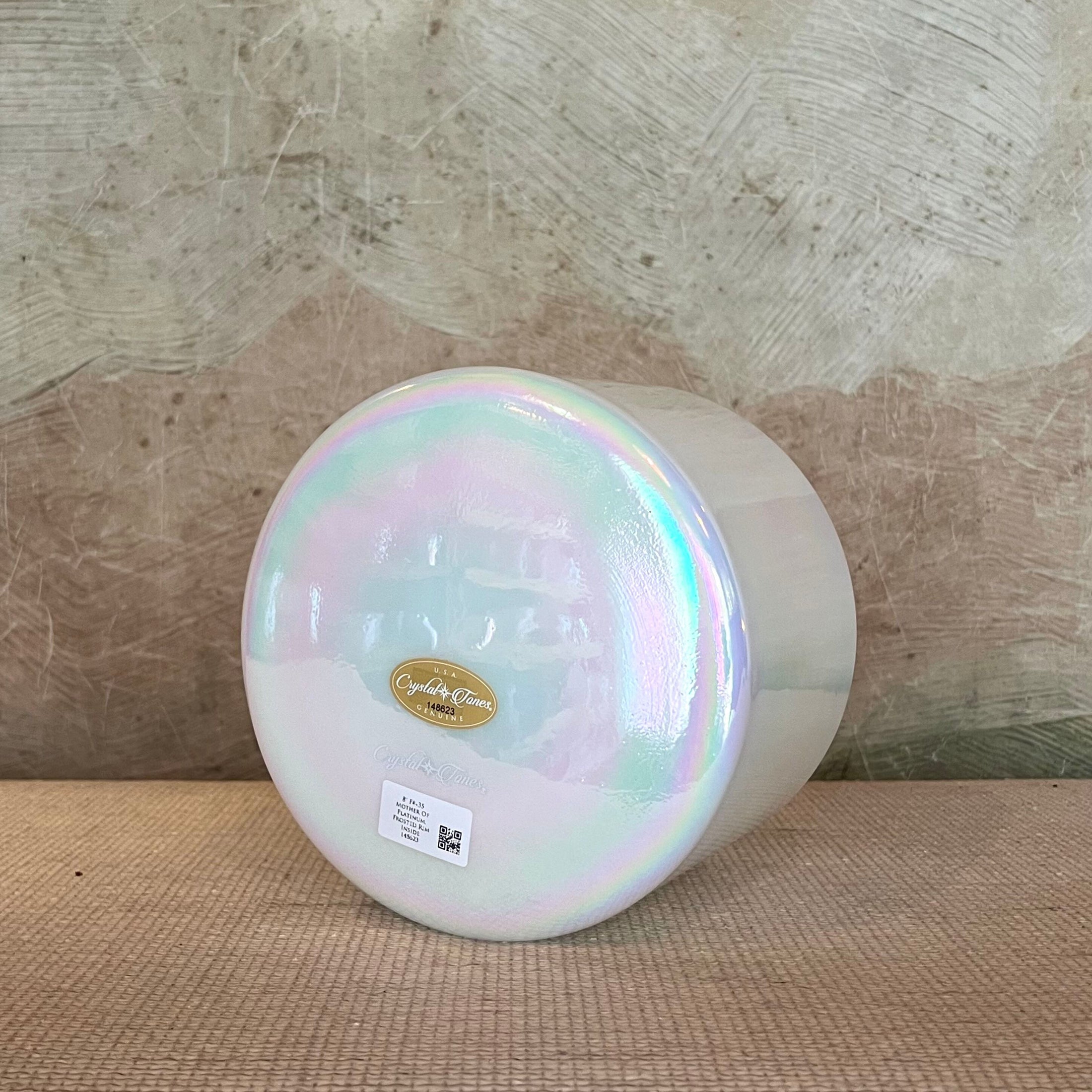 Iridescent Crystal Sound Bowl with a visible Crystal Tones brand label on a textured surface