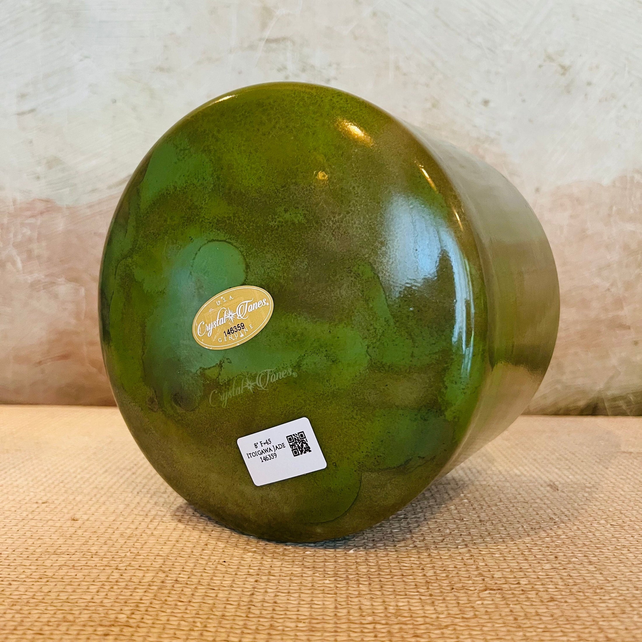 Green Crystal Sound Bowl with a visible Crystal Tones brand label on a textured surface