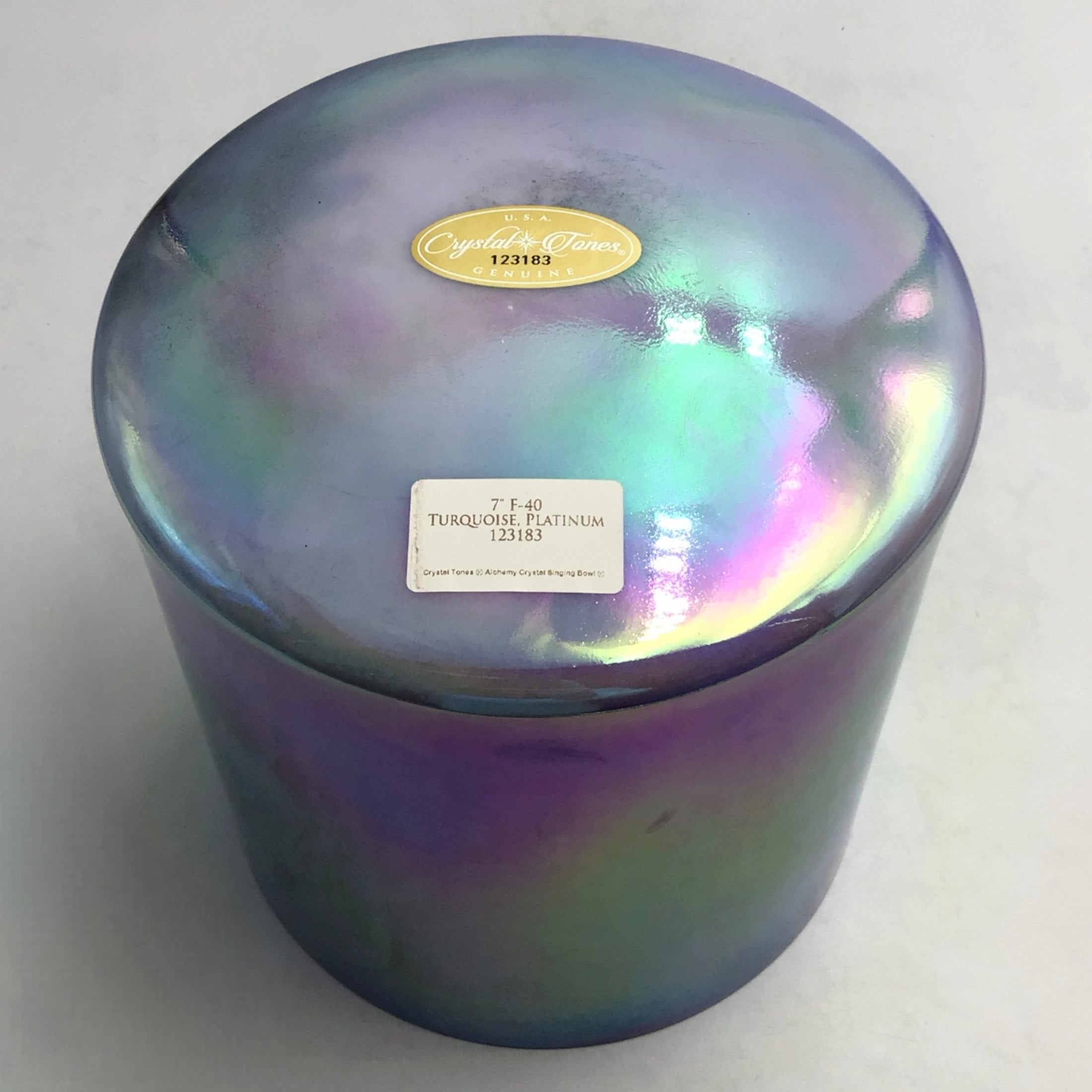 Iridescent crystal sound bowl with a label on a white background