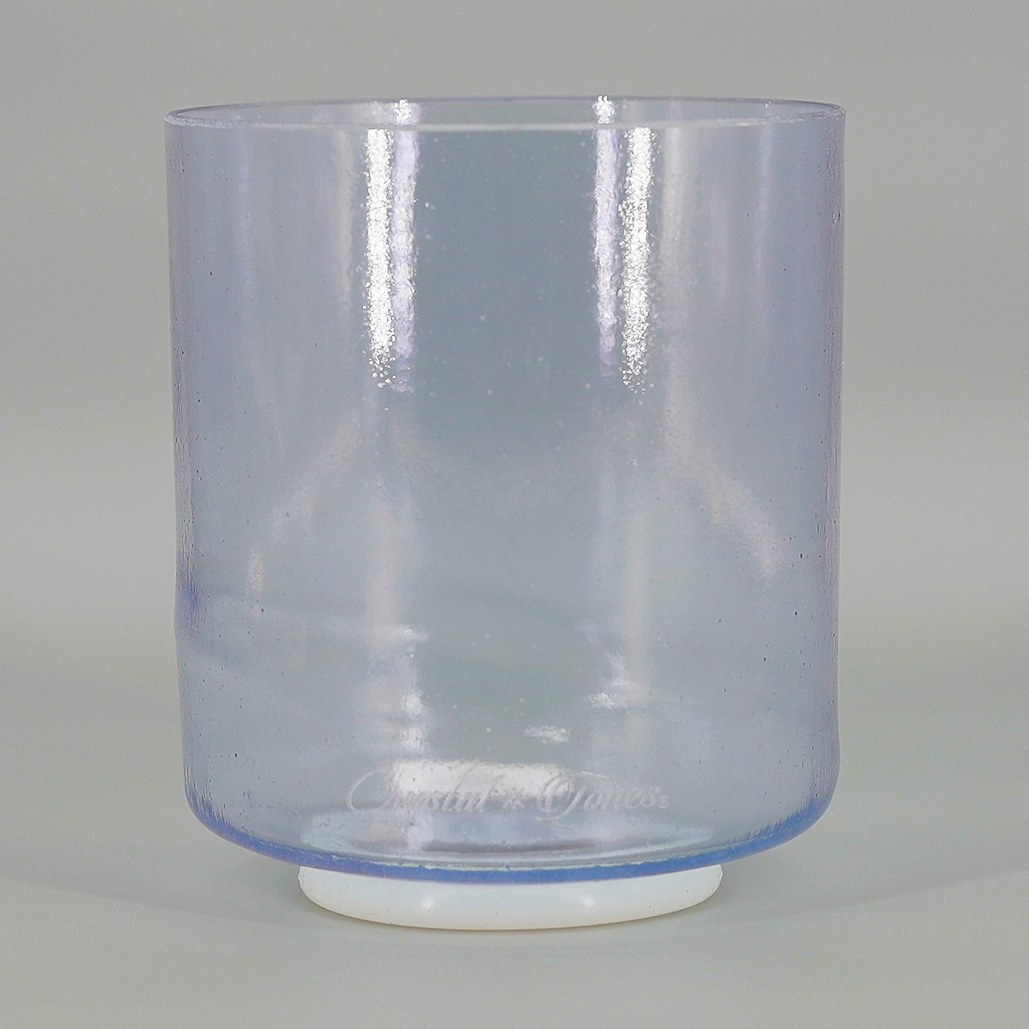 Clear blue crystal sound bowl with white base on a gray background