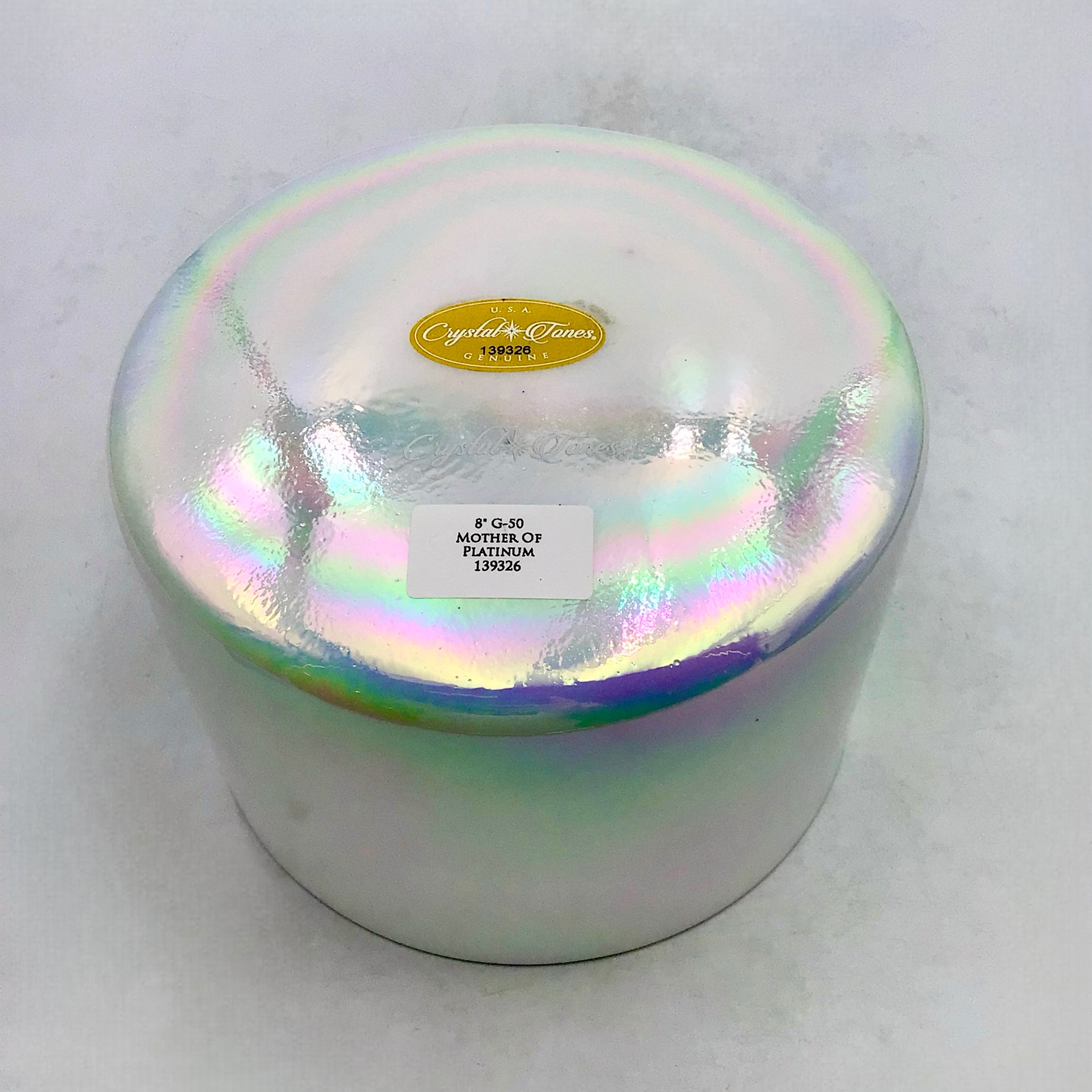 Iridescent crystal sound bowl with a label on a white background