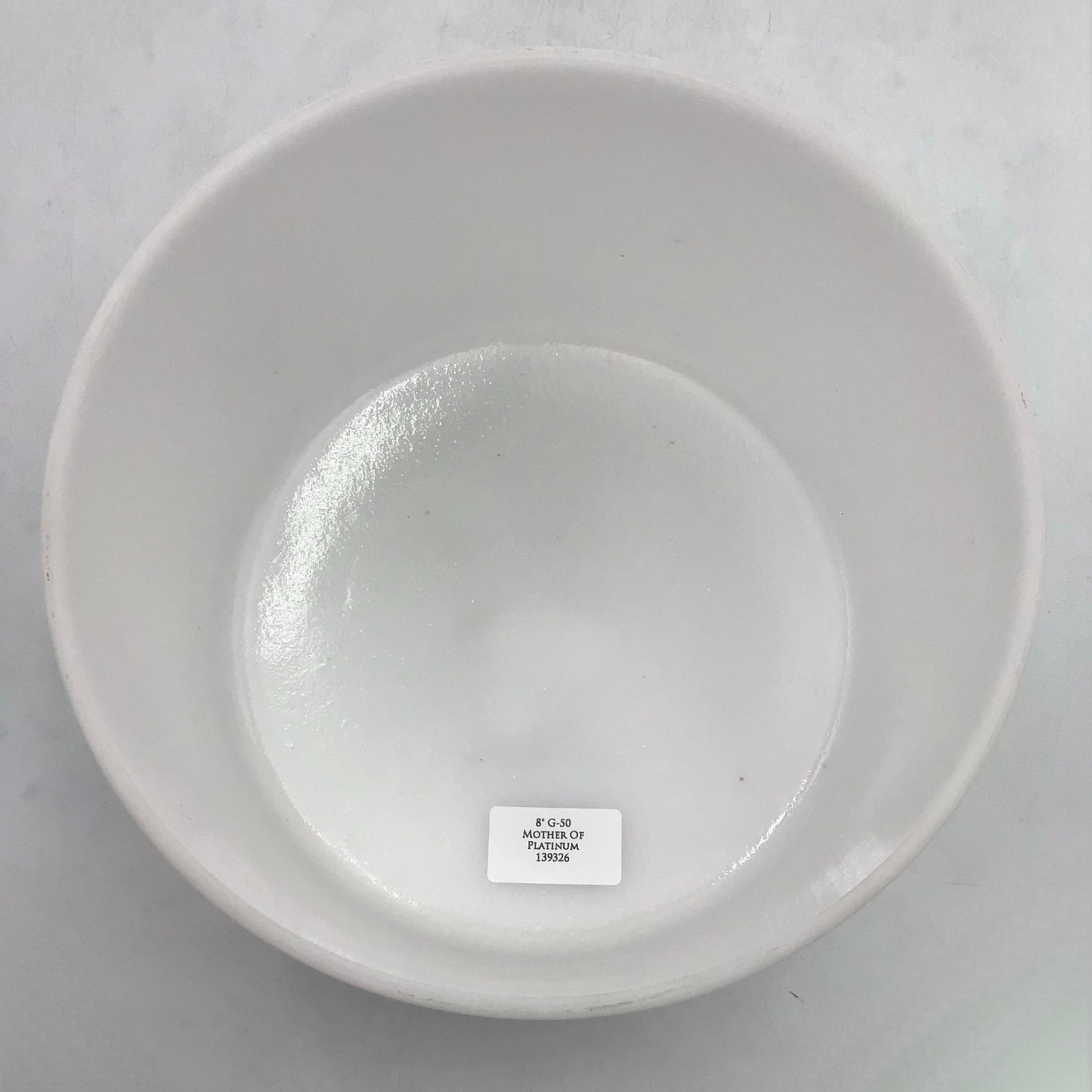 White crystal sound bowl on a light gray background