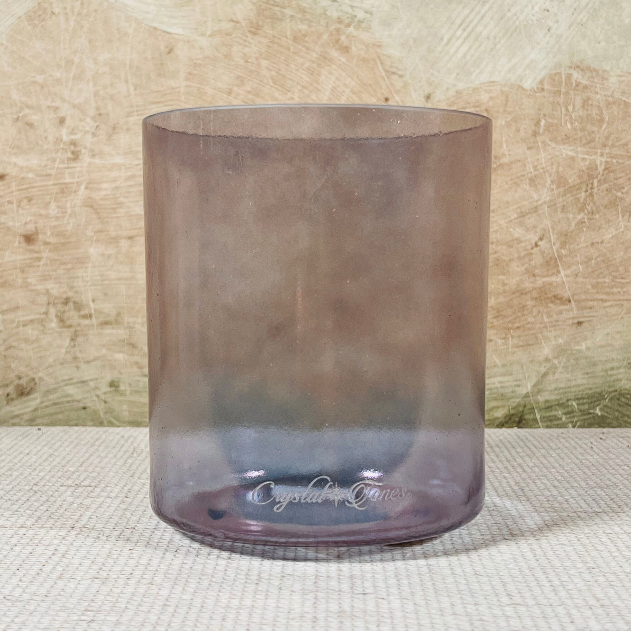 Smoky crystal sound bowl with 'Crystal Tones' branding on a textured surface.