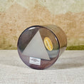 Load image into Gallery viewer, Cylindrical crystal sound bowl in a metallic container with a label on a textured surface
