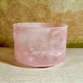 Load image into Gallery viewer, Pink crystal sound bowl on a textured surface with a wooden background
