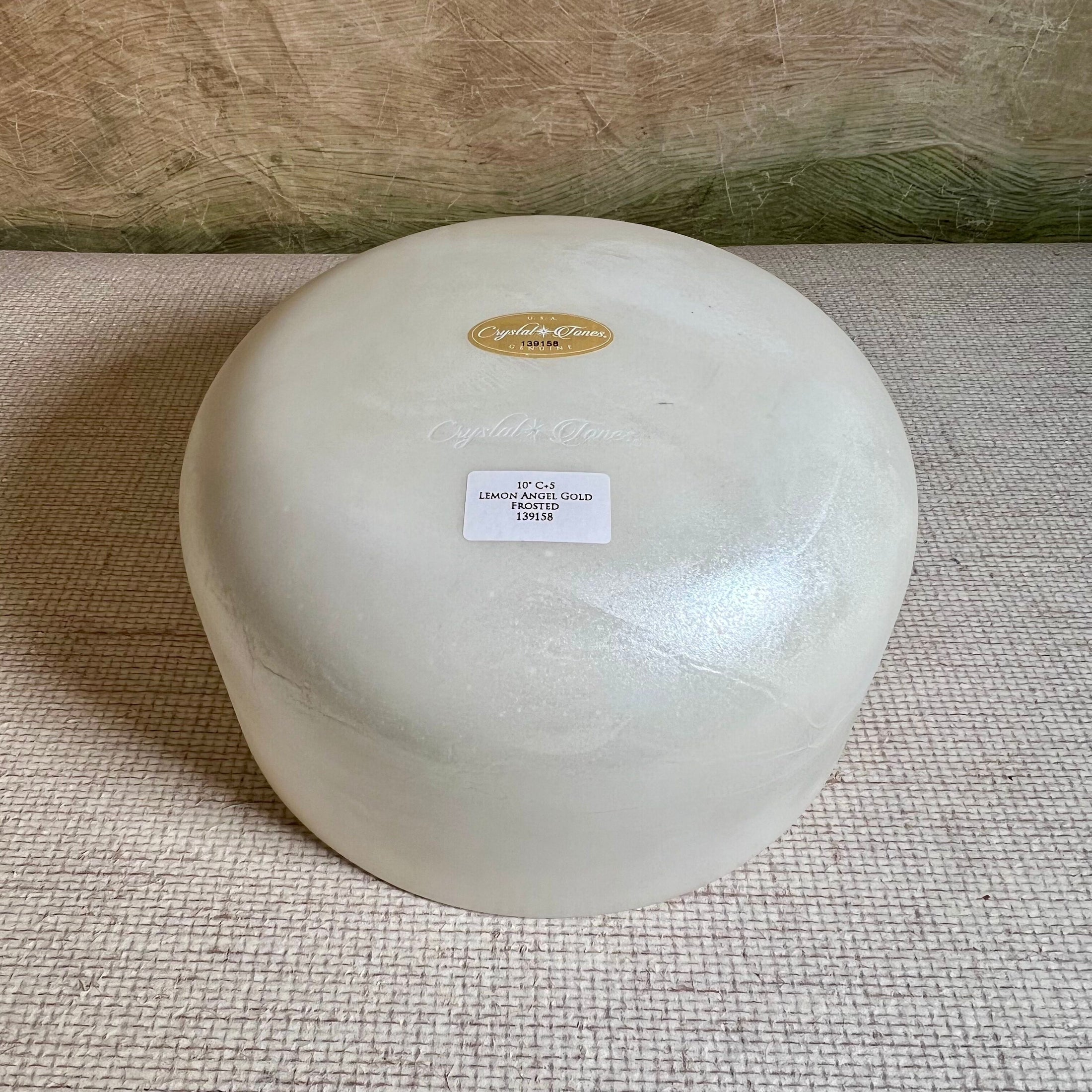Round white sound bowl with a Crystal Tones label on a textured surface