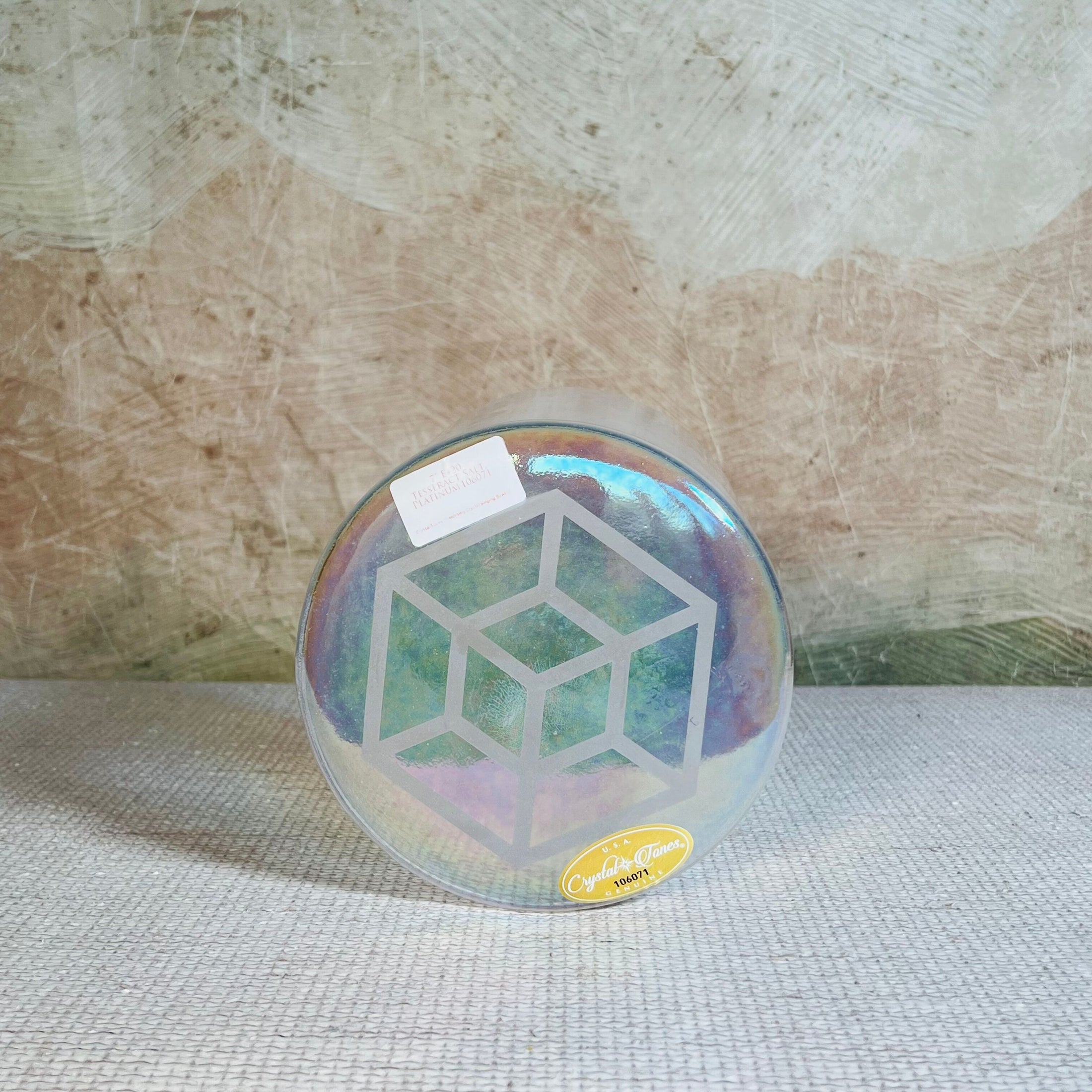 Iridescent crystal sound bowl with a design on a textured surface