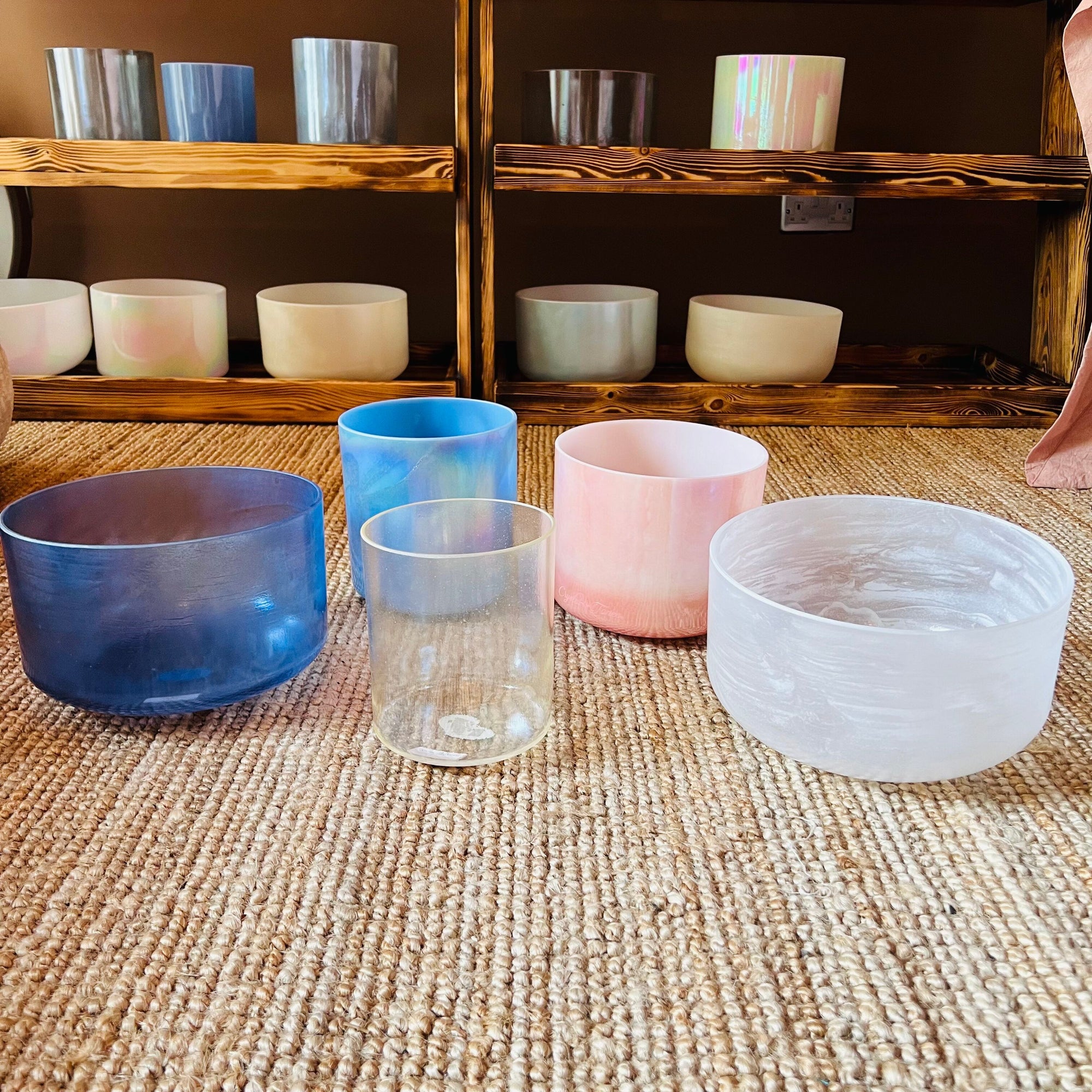 Colorful Crystal Sound Bowl on a textured surface with shelves in the background