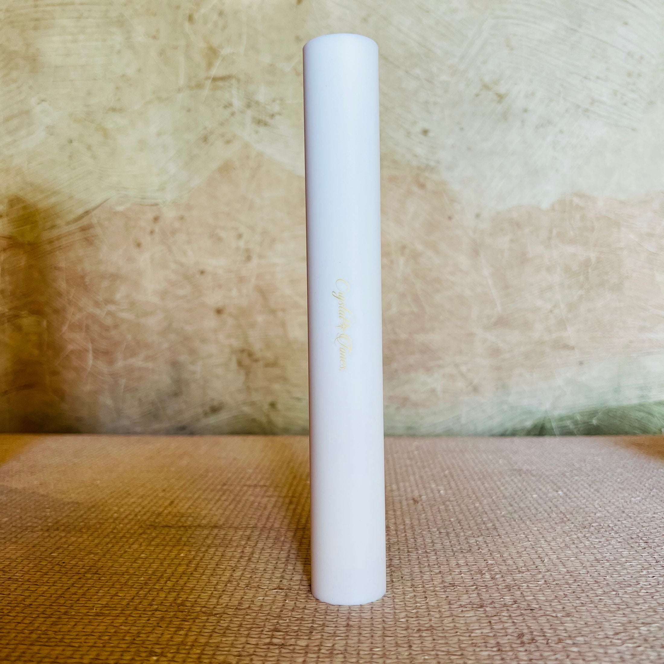 White cylindrical sonic mallet on a textured surface