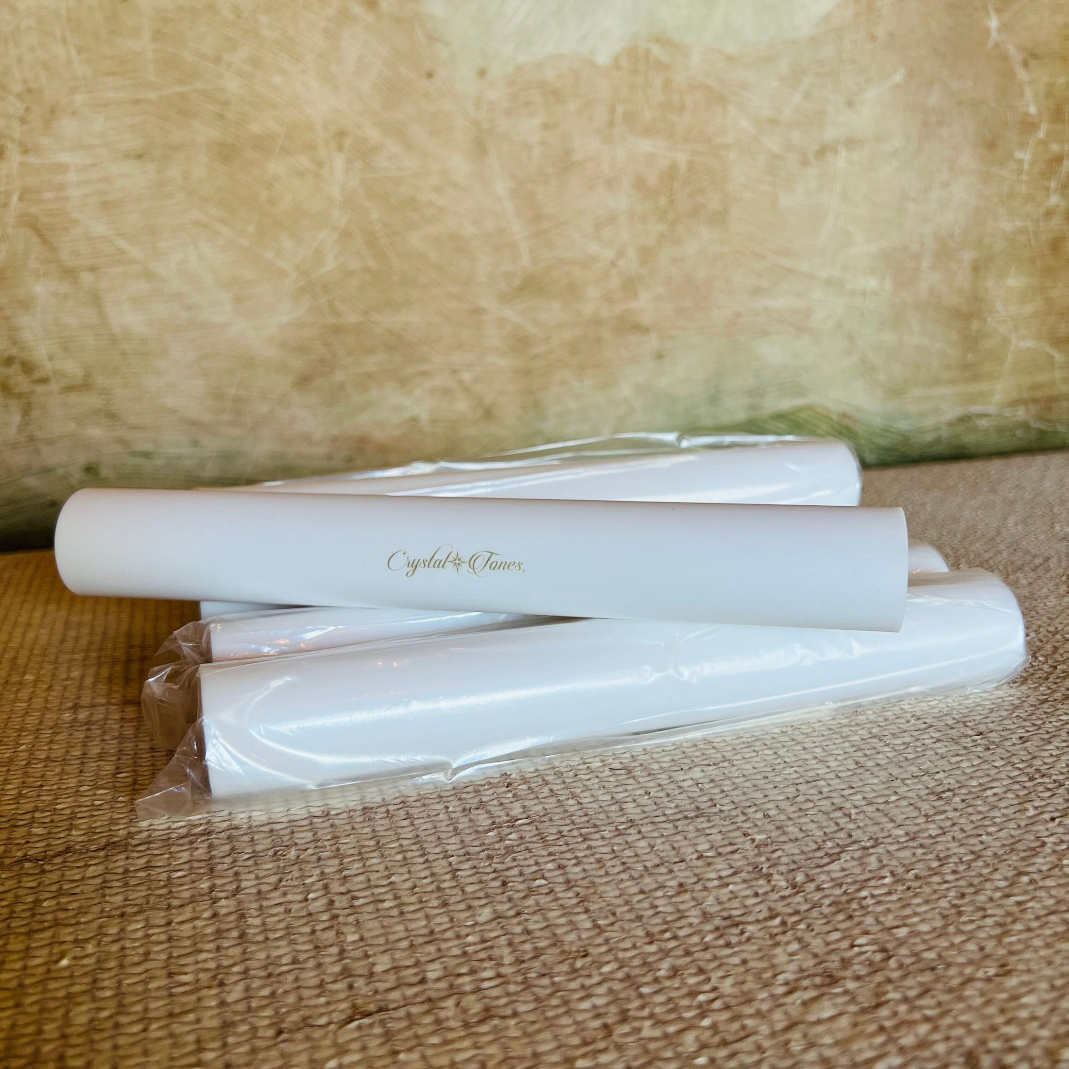 White sonic mallets with 'Crystal Tones' branding on a textured brown surface