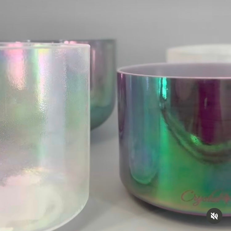 Iridescent singing bowls on a white surface with a blurred background